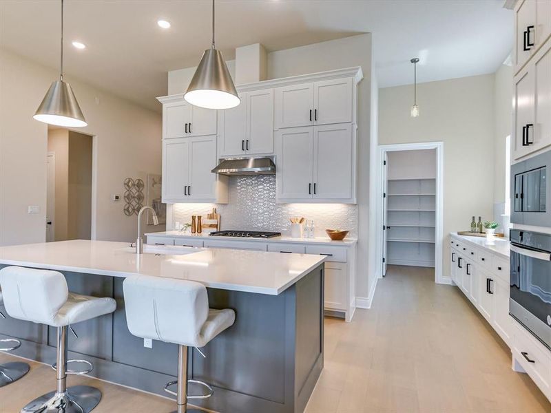 Check out the walk-in pantry and buffet-style cabinetry! Load of storage in this gorgeous kitchen!