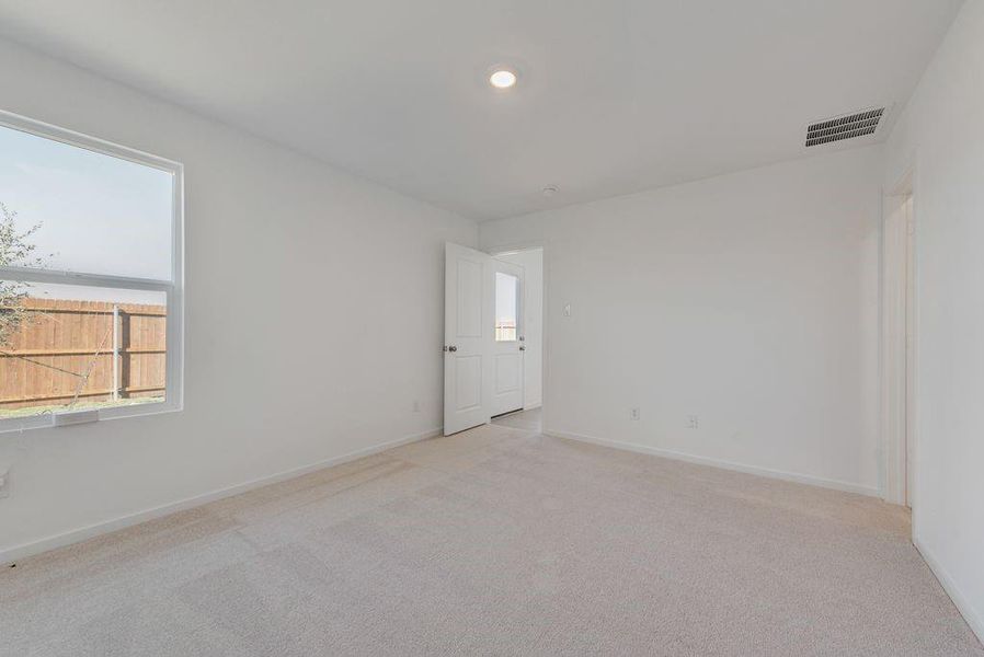 Unfurnished room featuring light carpet, plenty of natural light, and recessed lighting