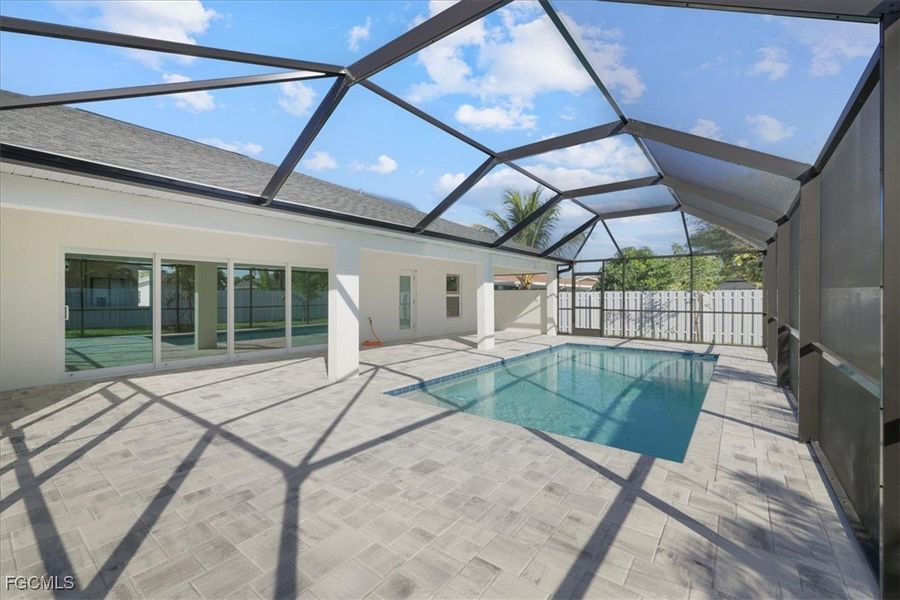 View of swimming pool featuring a sunroom, a patio area, and glass enclosure