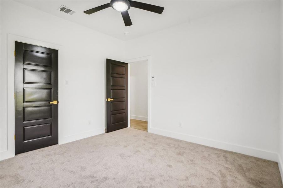 Unfurnished bedroom with carpet floors and a ceiling fan Unfurnished bedroom with carpet floors and a ceiling fan