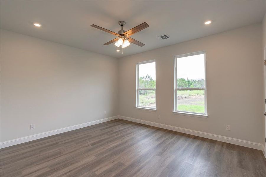 Unfurnished room with dark wood-type flooring and ceiling fan