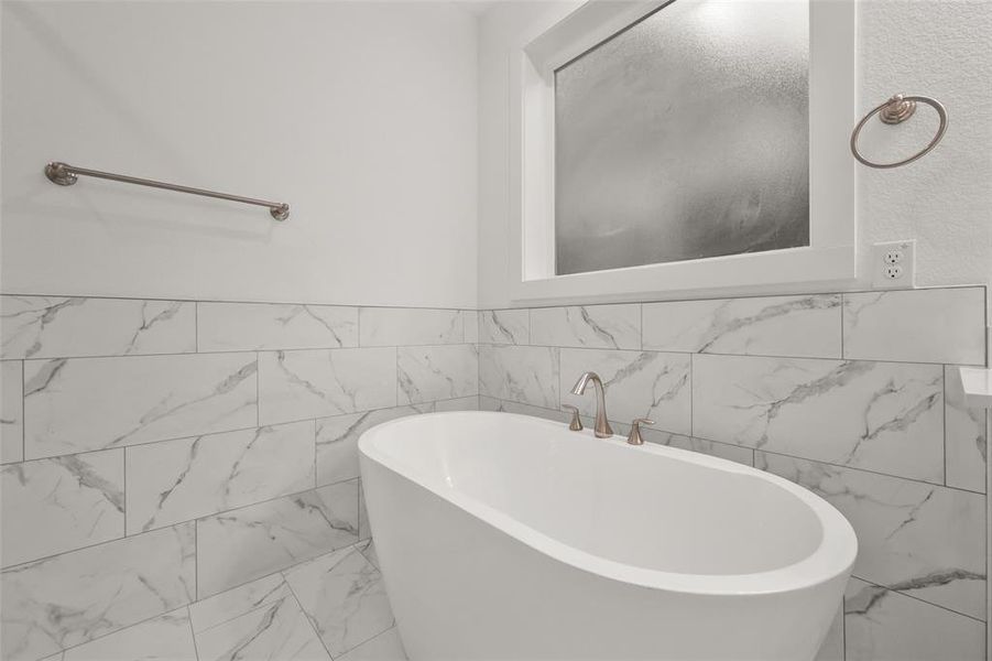 Primary bathroom with two sinks, tile floors, and a separate shower and tub.