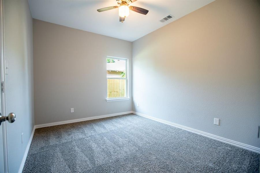 Carpeted spare room featuring ceiling fan