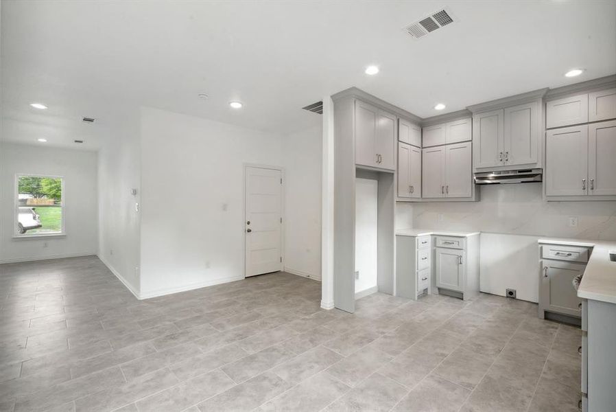 Kitchen featuring gray cabinets and light tile patterned flooring