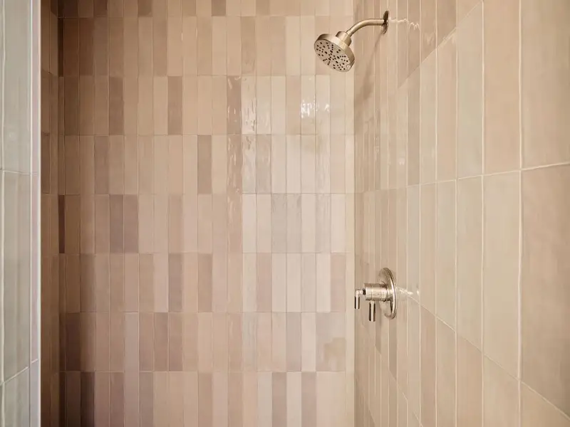 A sleek, fully tiled shower with modern fixtures. A sleek, fully tiled shower with modern fixtures.