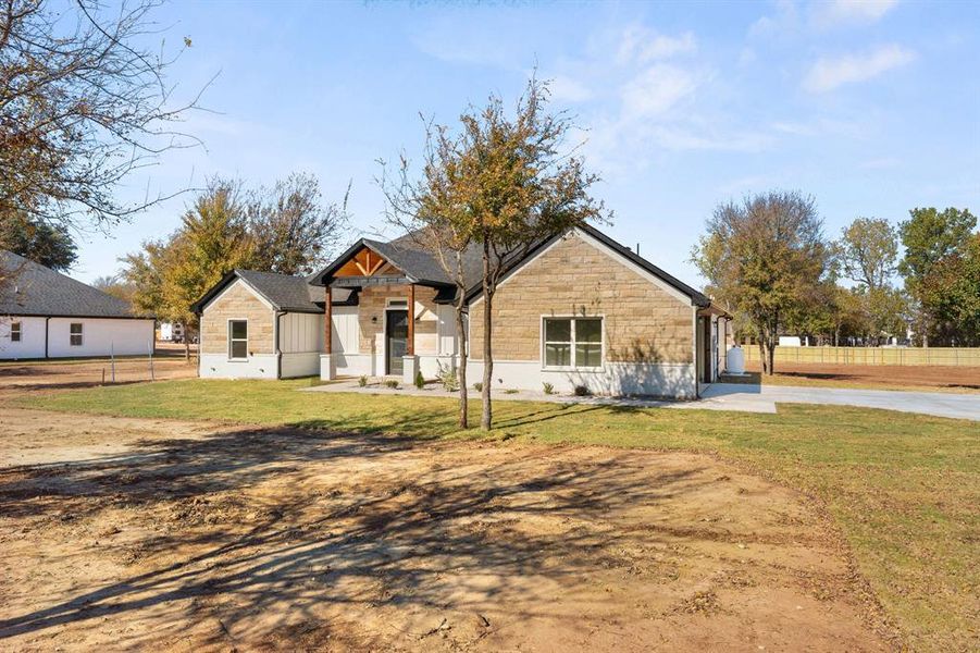 View of front of property with stone siding and driveway