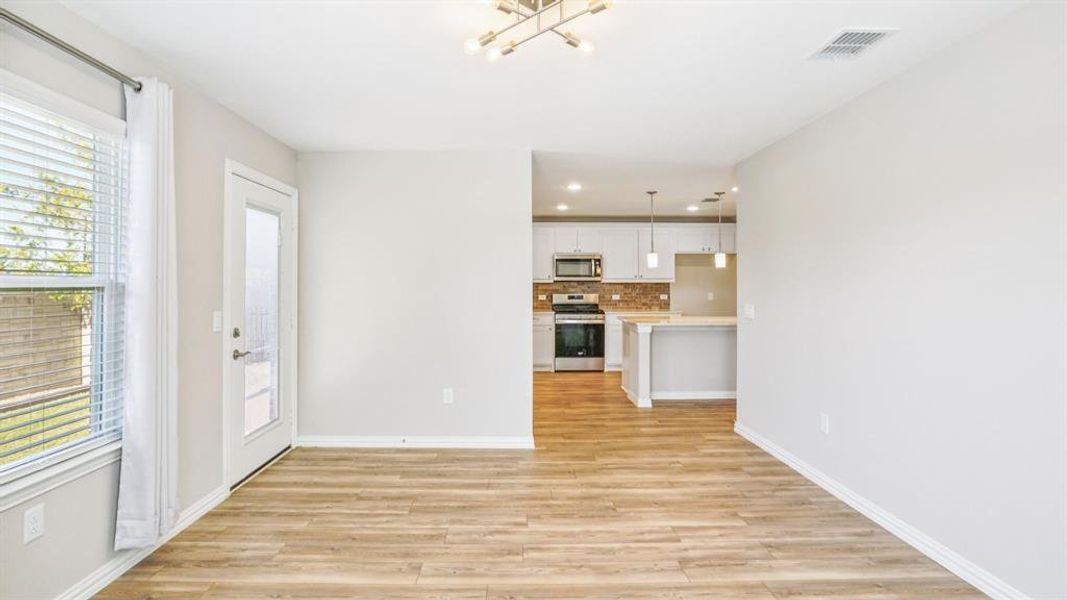 Unfurnished living room with light wood finished floors, a chandelier, and recessed lighting Unfurnished living room with light wood finished floors, a chandelier, and recessed lighting