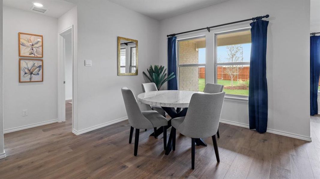 Dining room with dark wood-style flooring and baseboards Dining room with dark wood-style flooring and baseboards
