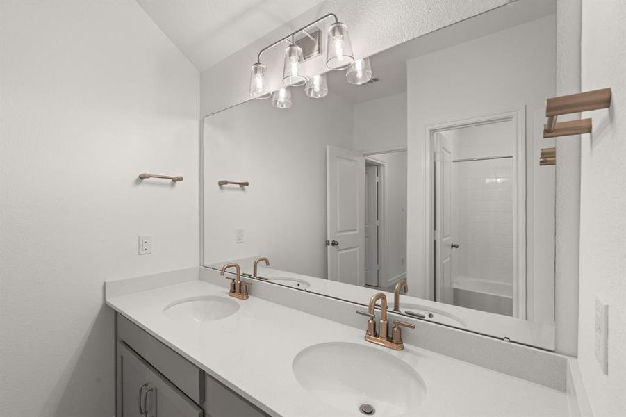 The secondary bath features tile flooring, white cabinetry and light countertops and a shower/tub combo. Perfect for accommodating any visiting family and friends.