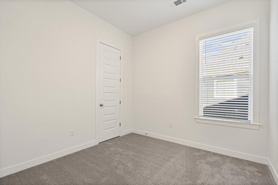 Carpeted empty room featuring baseboards