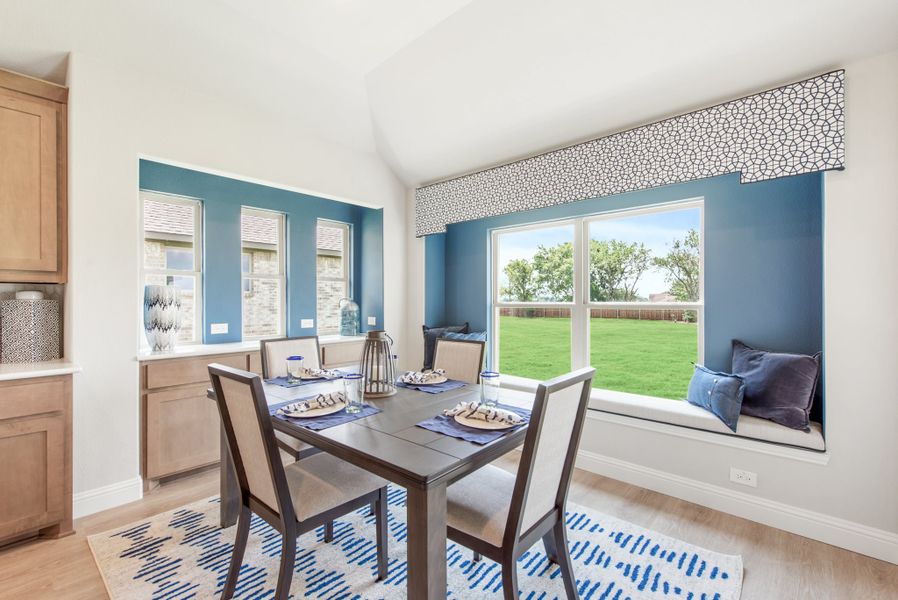 Dining area with dark wood table, four chairs, window seat, and blue accent walls
