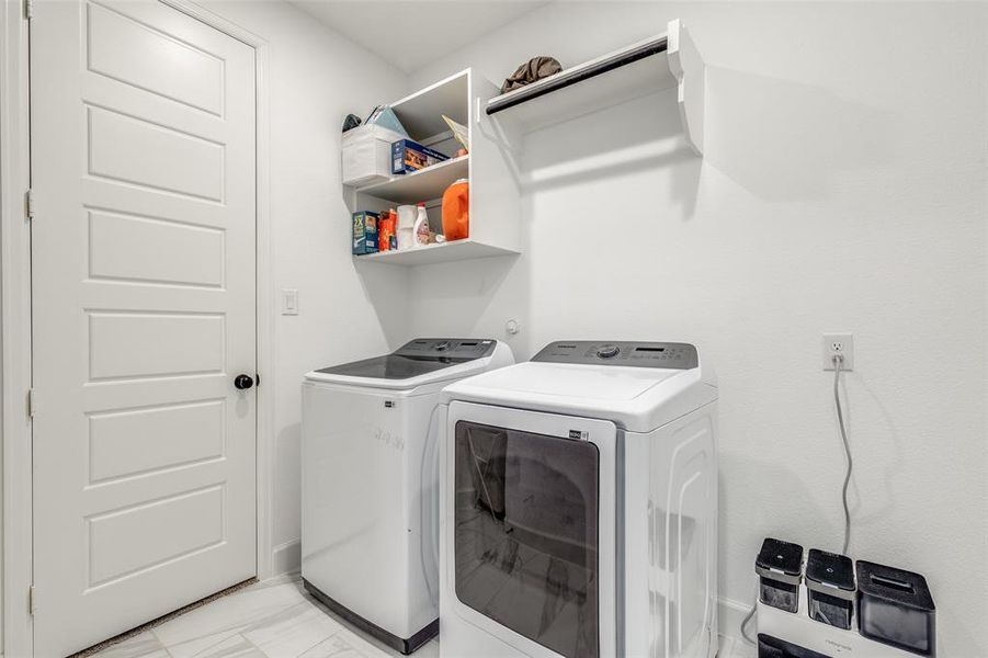 Laundry room featuring washing machine and clothes dryer and light marble finish floors