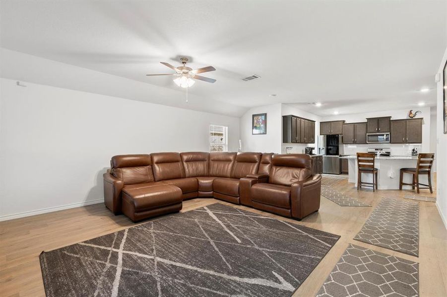 Living area with light wood-type flooring, ceiling fan, lofted ceiling, and recessed lighting