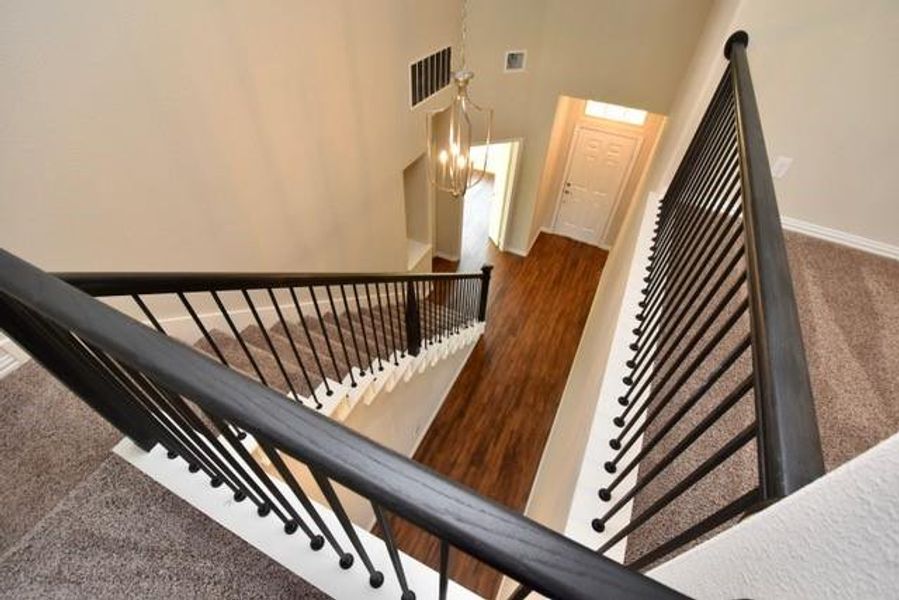 Stairway featuring a high ceiling and a ceiling fan Stairway featuring a high ceiling and a ceiling fan