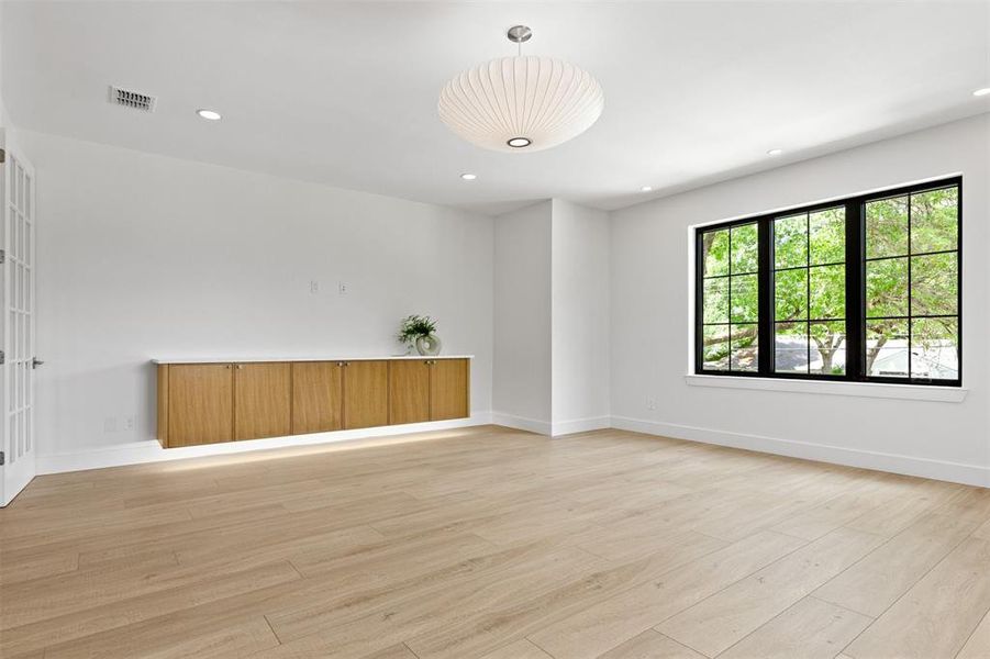 Empty room with light wood finished floors and recessed lighting