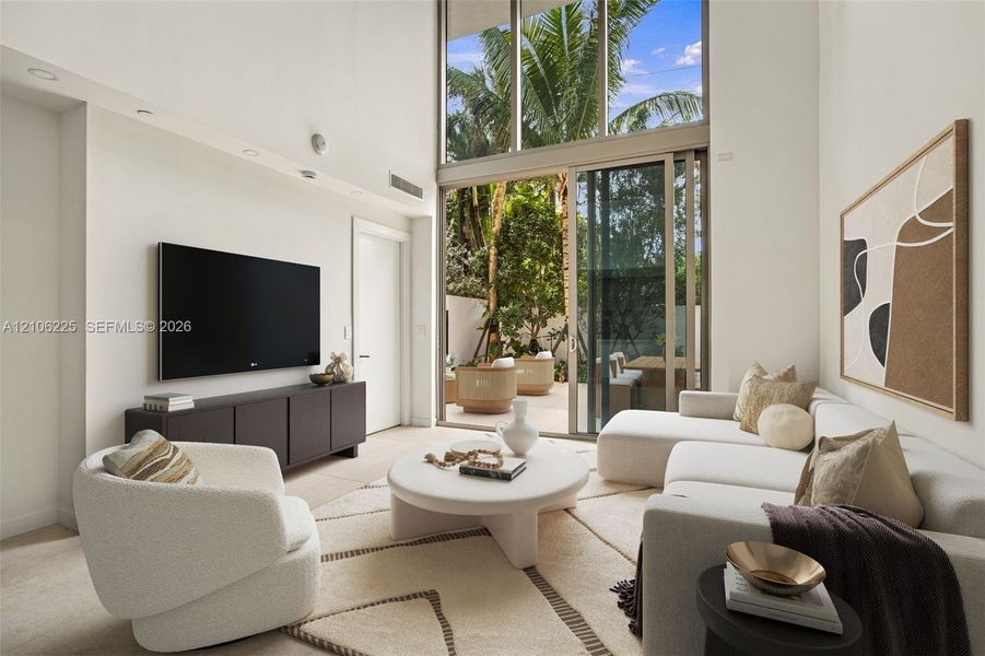Double-height ceilings, floor-to-ceiling windows, and expansive sliding glass doors providing outdoor access Double-height ceilings, floor-to-ceiling windows, and expansive sliding glass doors providing outdoor access