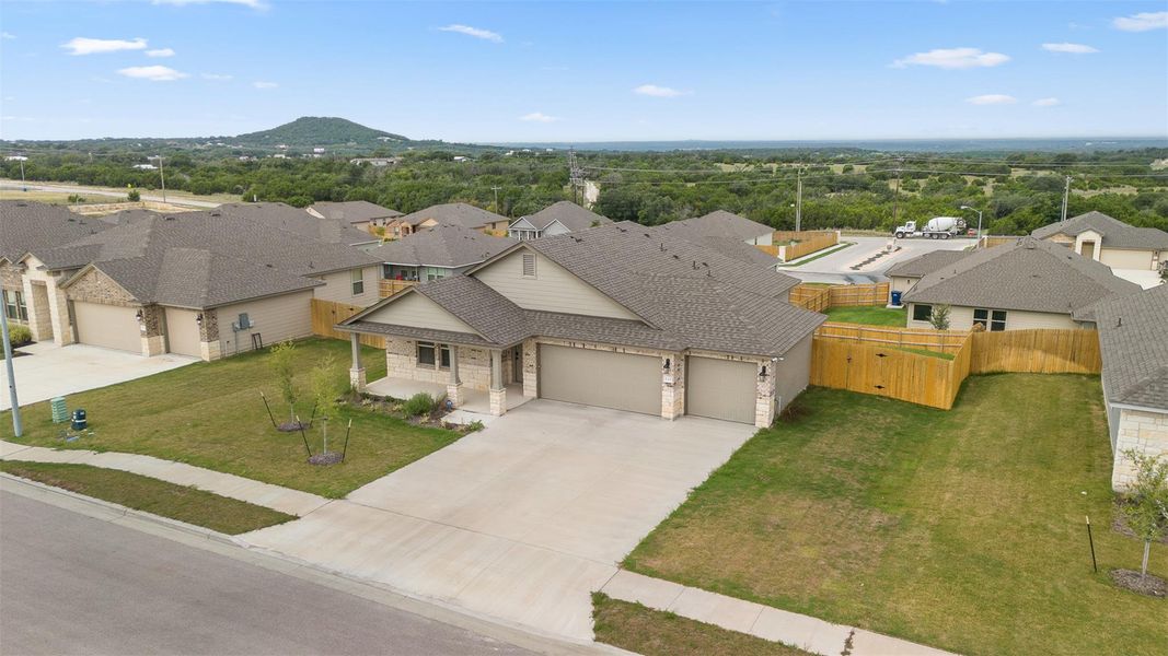 View of front facade with a residential view, a garage, a gate, driveway, and a shingled roof