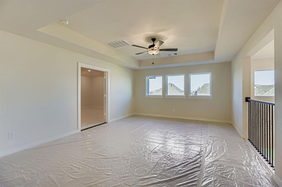 Unfurnished room with a raised ceiling and ceiling fan