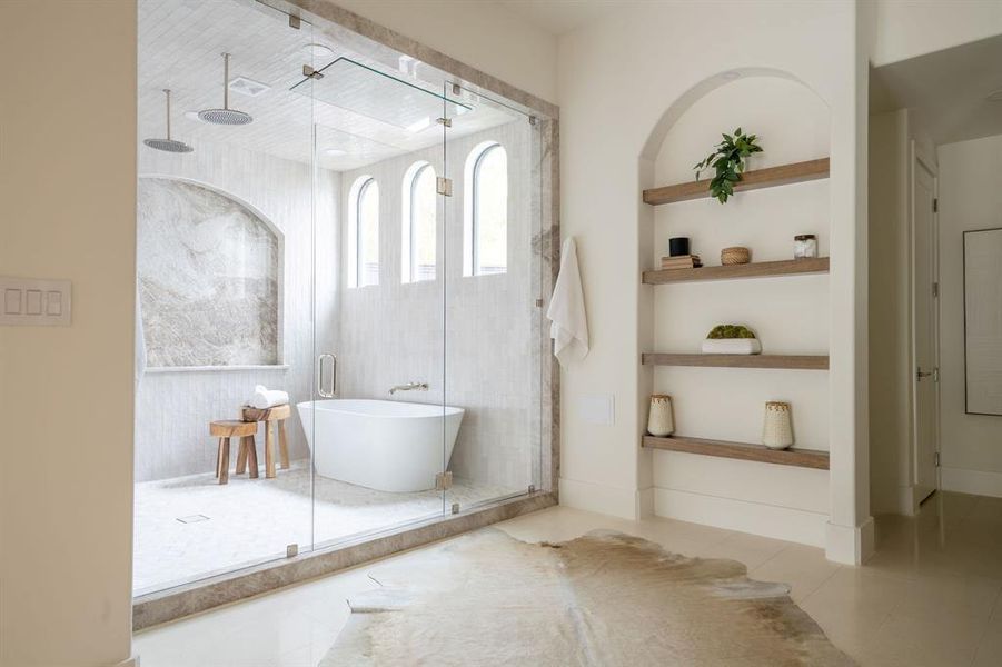 Full bathroom featuring tile patterned flooring, built in shelves, a stall shower, and a freestanding tub