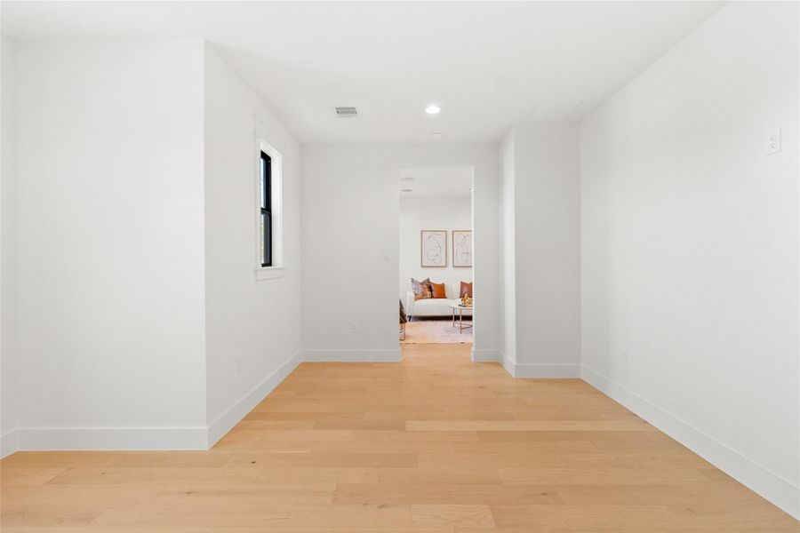 You step into this private speakeasy-style room tucked away from the main living areas—a clean, minimalist space designed to transform into whatever your lifestyle calls for. Whether you envision a hidden lounge, tasting room, or vinyl listening space, the crisp white walls and warm wood floors give you a blank canvas to create something truly personal and unexpected.