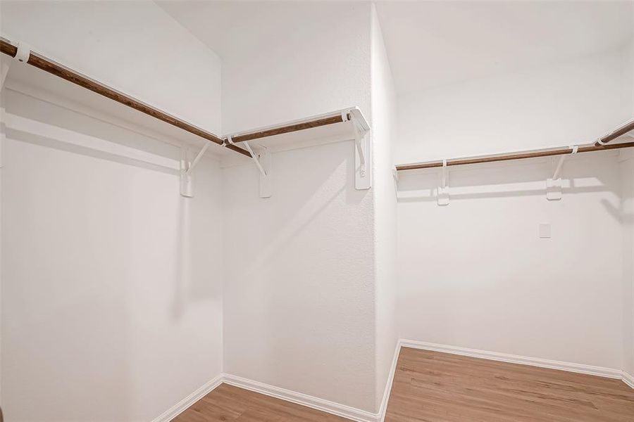 The primary closet also features shelving for additional storage, keeping everything organized and within reach.