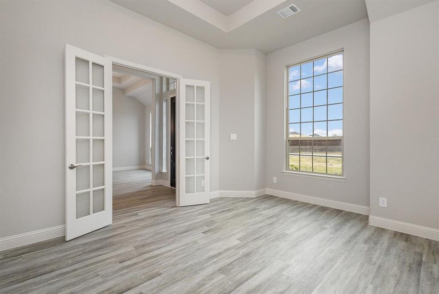 Unfurnished room with light wood-type flooring and french doors