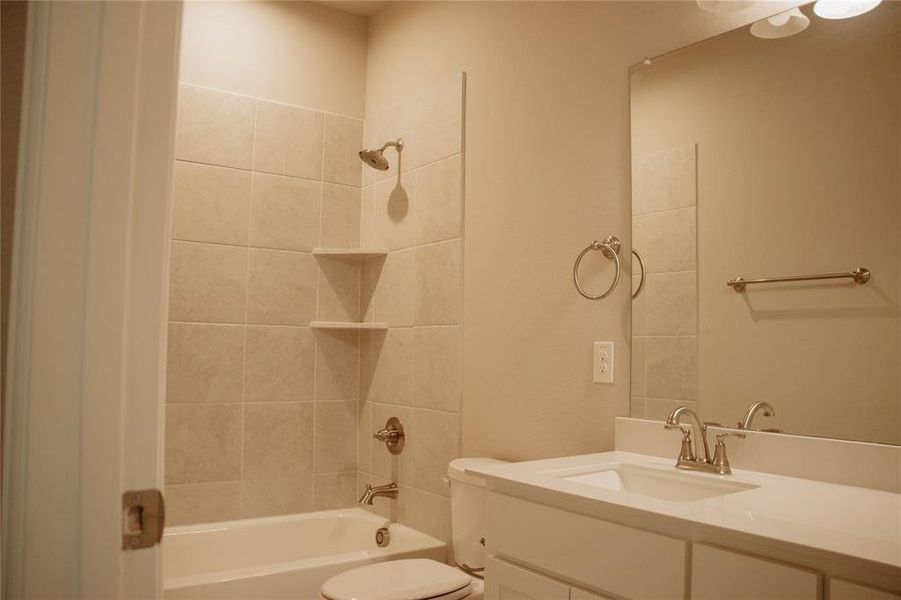 Full bathroom with vanity, toilet, and tiled shower / bath