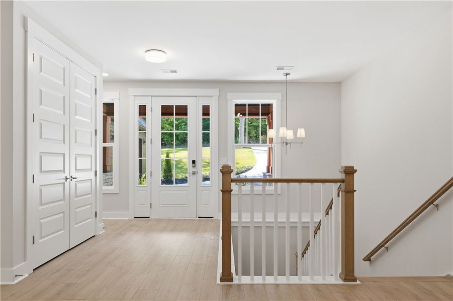 A welcoming entryway features handsome wood floori