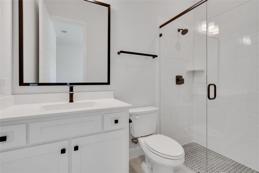 Bathroom with an enclosed shower, oversized vanity, and toilet