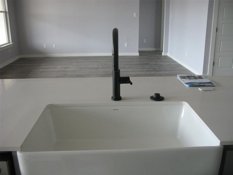 Kitchen view of a sink and light countertops