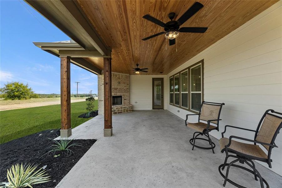 View of patio featuring an outdoor brick fireplace and ceiling fan View of patio featuring an outdoor brick fireplace and ceiling fan