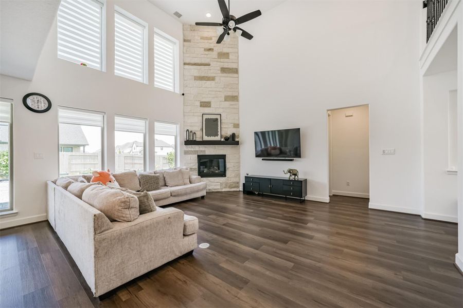 A stunning open-concept home featuring soaring ceilings, a breathtaking wall of windows, and a striking two-story stone fireplace with a gas log insert. A stunning open-concept home featuring soaring ceilings, a breathtaking wall of windows, and a striking two-story stone fireplace with a gas log insert.