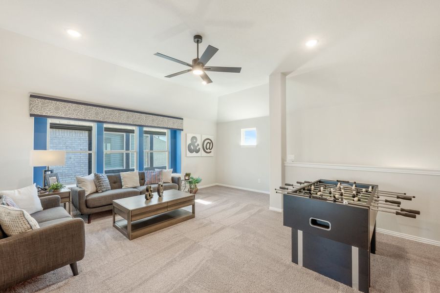 Game room with foosball table, gray sofa seating, ceiling fan, and carpet flooring