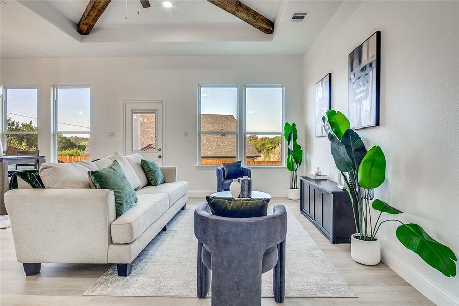 Living room featuring beam ceiling, light wood-type flooring, and a ceiling fan Living room featuring beam ceiling, light wood-type flooring, and a ceiling fan