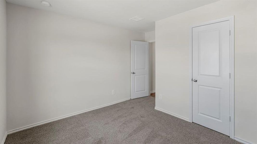 Spacious room featuring light gray carpeting and bright white walls