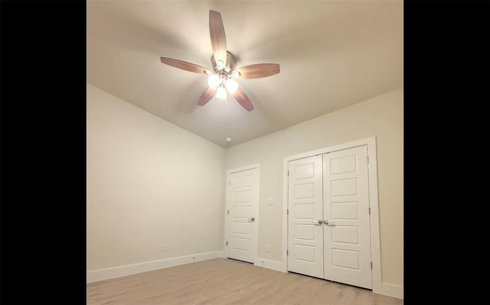 Bedroom with ceiling fan, closet, and high white baseboards