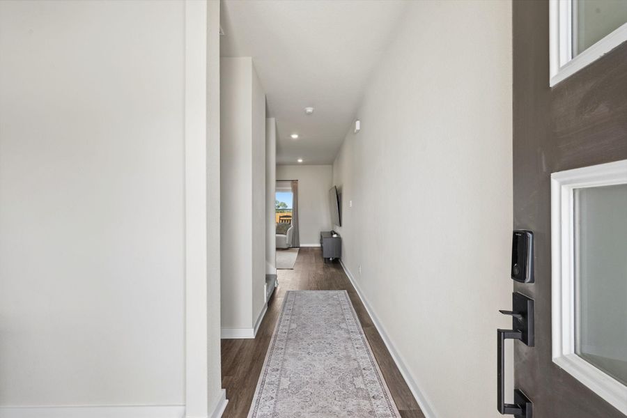 A welcoming entryway with durable wood flooring leads into a long, bright hall. A welcoming entryway with durable wood flooring leads into a long, bright hall.