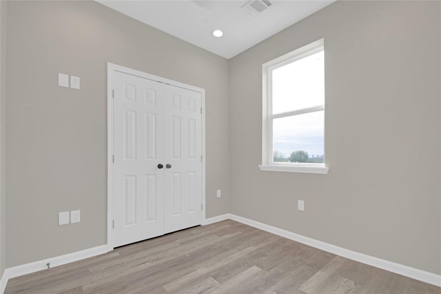 Unfurnished bedroom with a closet, light wood finished floors, and recessed lighting