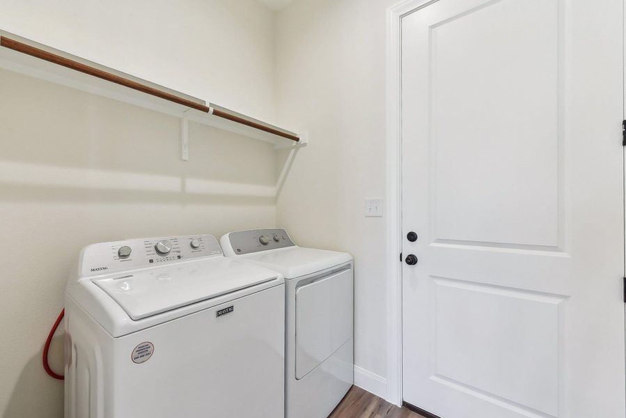 Clothes washing area with laundry area, wood finished floors, and washing machine and clothes dryer Clothes washing area with laundry area, wood finished floors, and washing machine and clothes dryer
