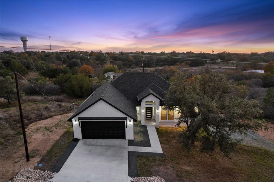 View of front of house with concrete driveway, stucco siding, and an attached garage