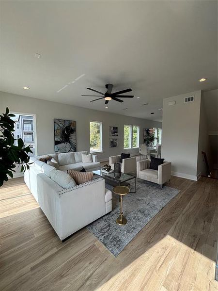 Living room featuring light wood-style flooring, recessed lighting, and a ceiling fan Living room featuring light wood-style flooring, recessed lighting, and a ceiling fan