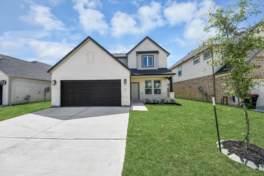 The residence features a practical 2-car garage complemented by a generous driveway, ensuring abundant space for parking needs.