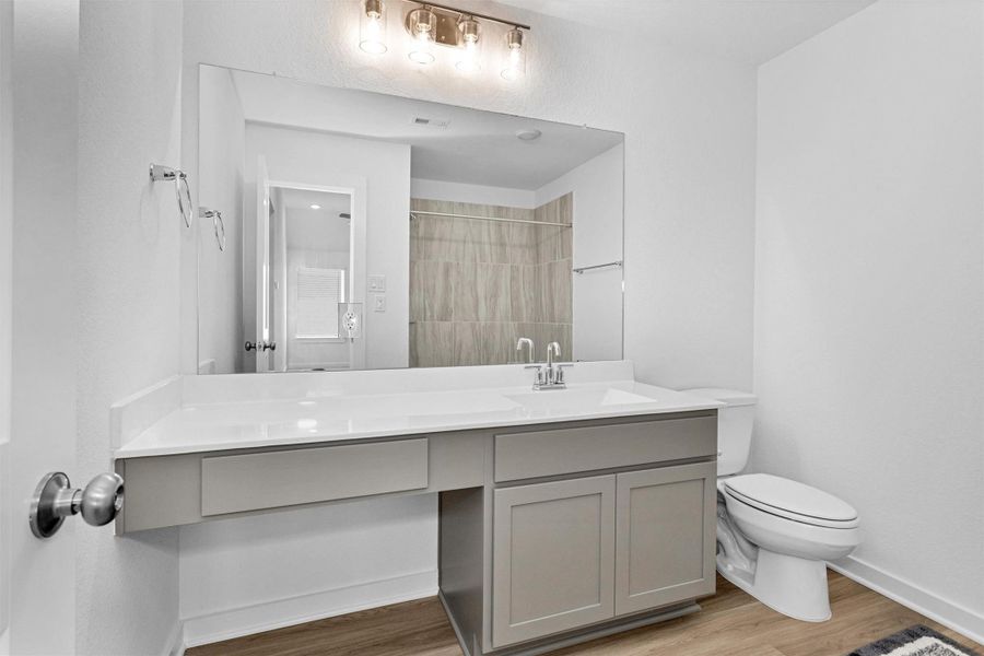 This upstairs full bathroom has never been used and features a spacious vanity and modern lighting,