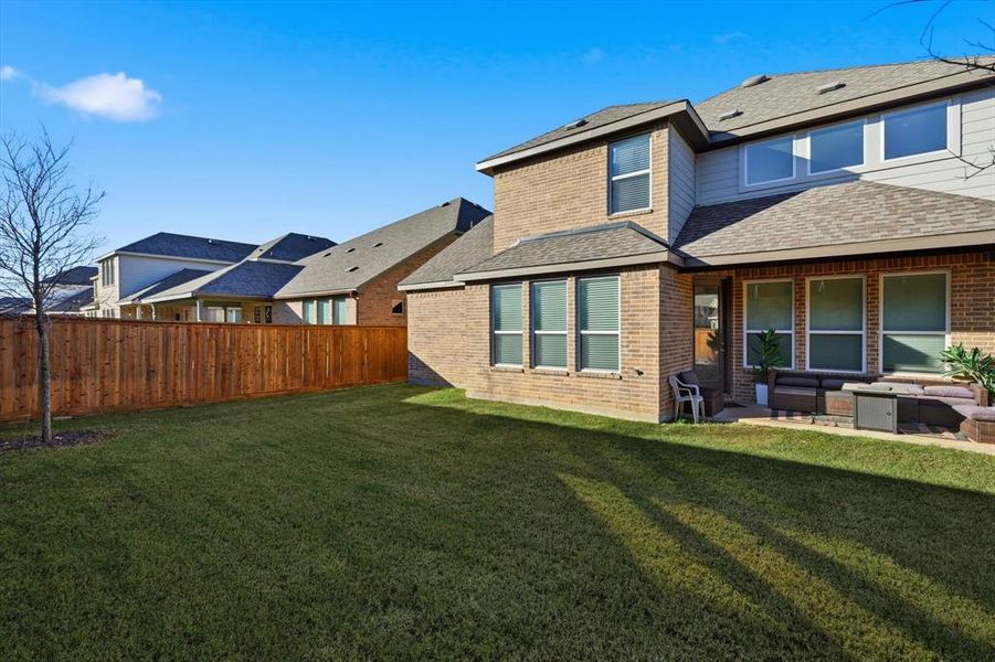 Rear view of property with an outdoor living space, roof with shingles, brick siding, and a patio area