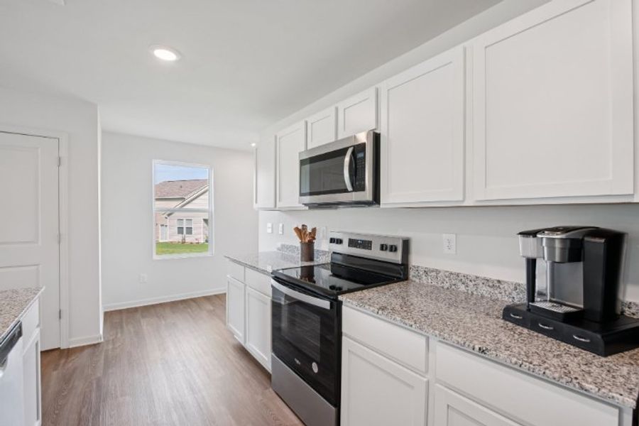 A kitchen with white cabinets.