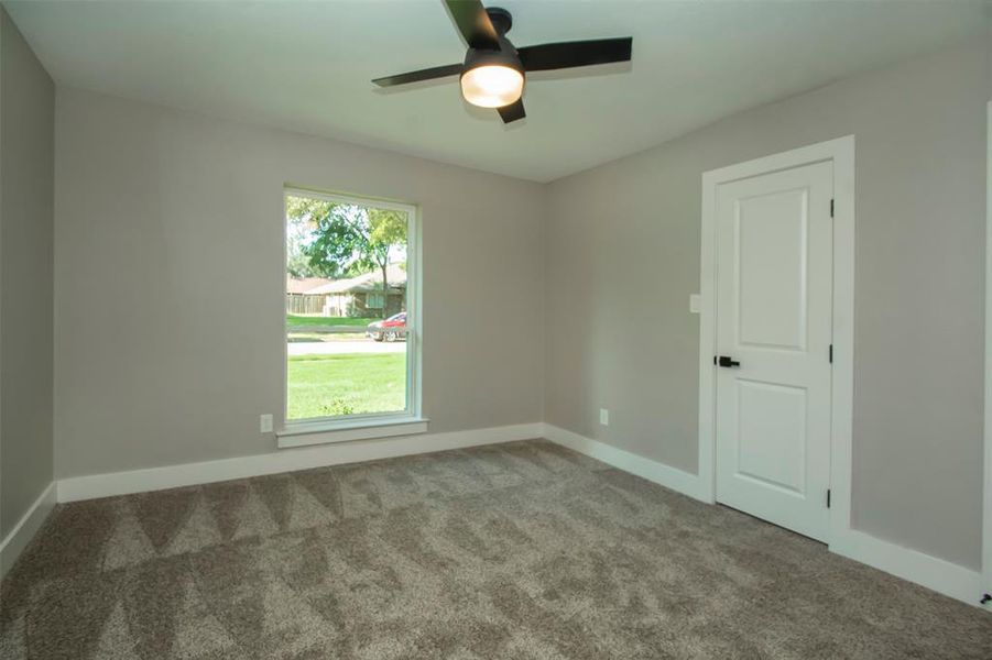 Carpeted spare room featuring ceiling fan