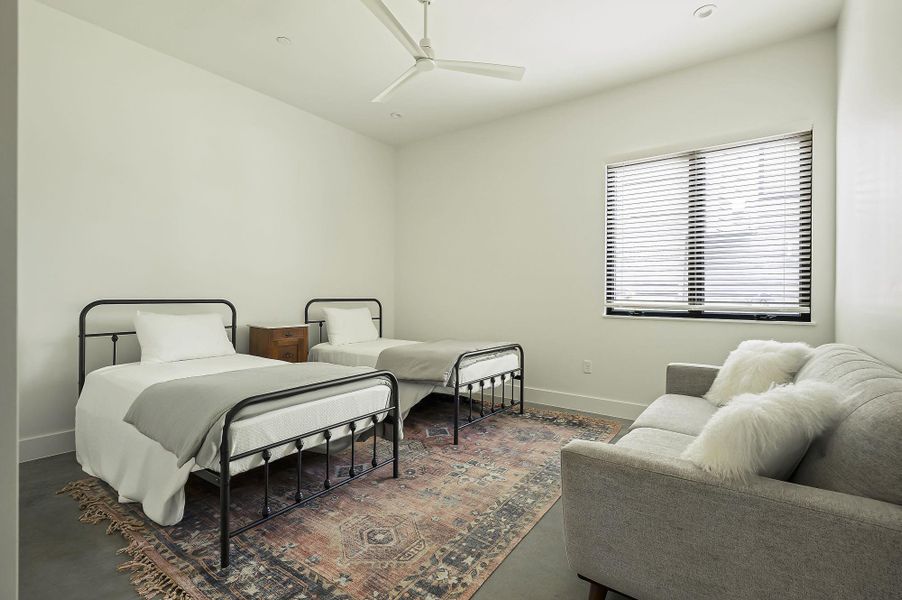 Bedroom with ceiling fan and concrete flooring Bedroom with ceiling fan and concrete flooring