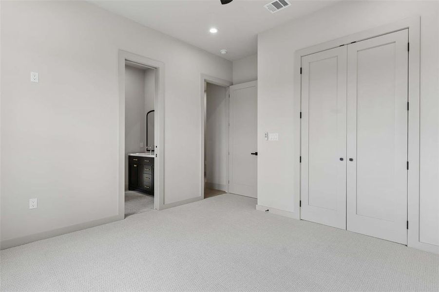 Second level bedroom featuring a spacious closet and private ensuite bathroom. Second level bedroom featuring a spacious closet and private ensuite bathroom.