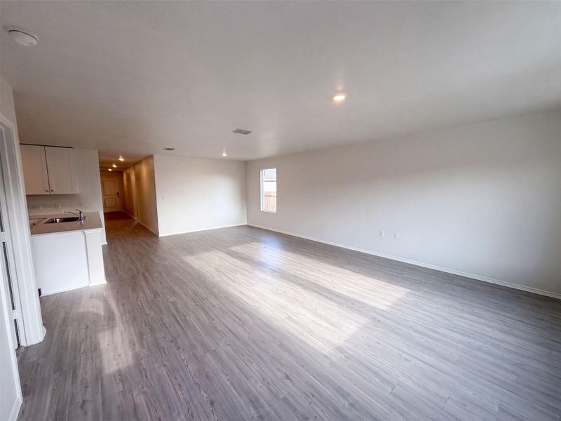 Clean modern finishes define this airy living space complete with plank flooring and recessed lighting.