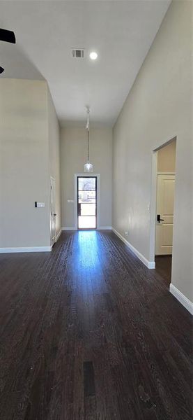 Unfurnished living room with dark wood finished floors and 15 ft high ceiling Unfurnished living room with dark wood finished floors and 15 ft high ceiling